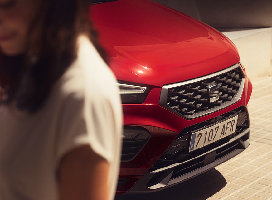 woman-standing-next-to-seat-ateca-velvet-red-colour